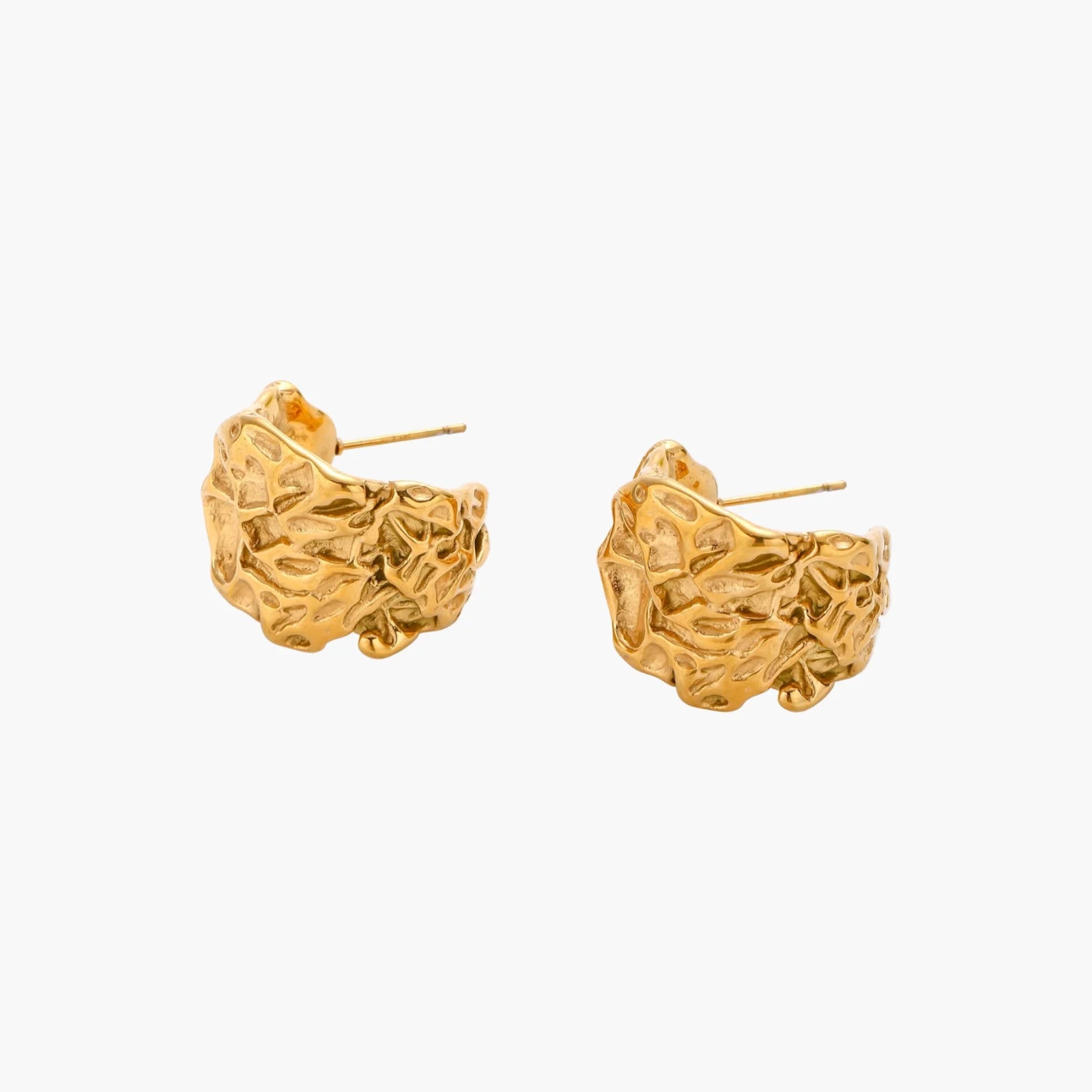 Sculptural gold-plated hoops with organic crushed texture on cream background