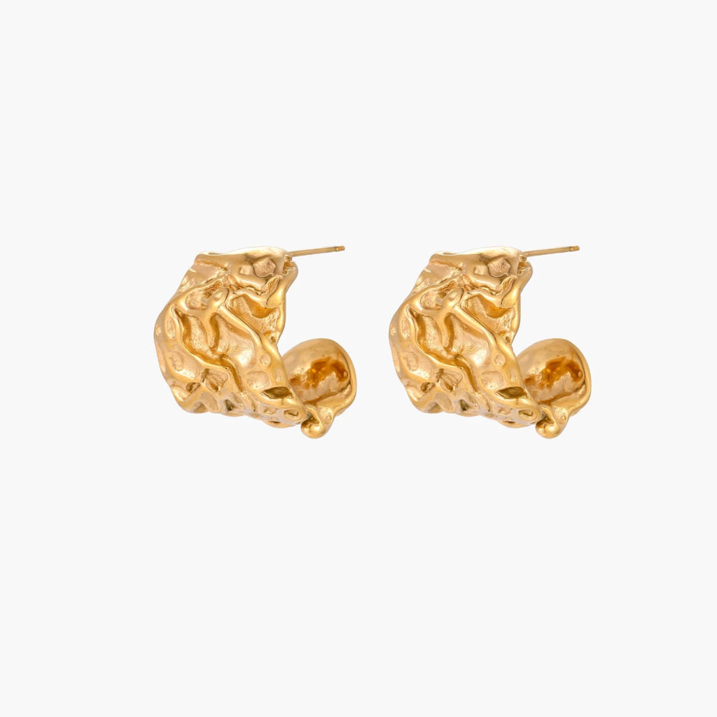 Sculptural gold-plated hoops with organic crushed texture on cream background