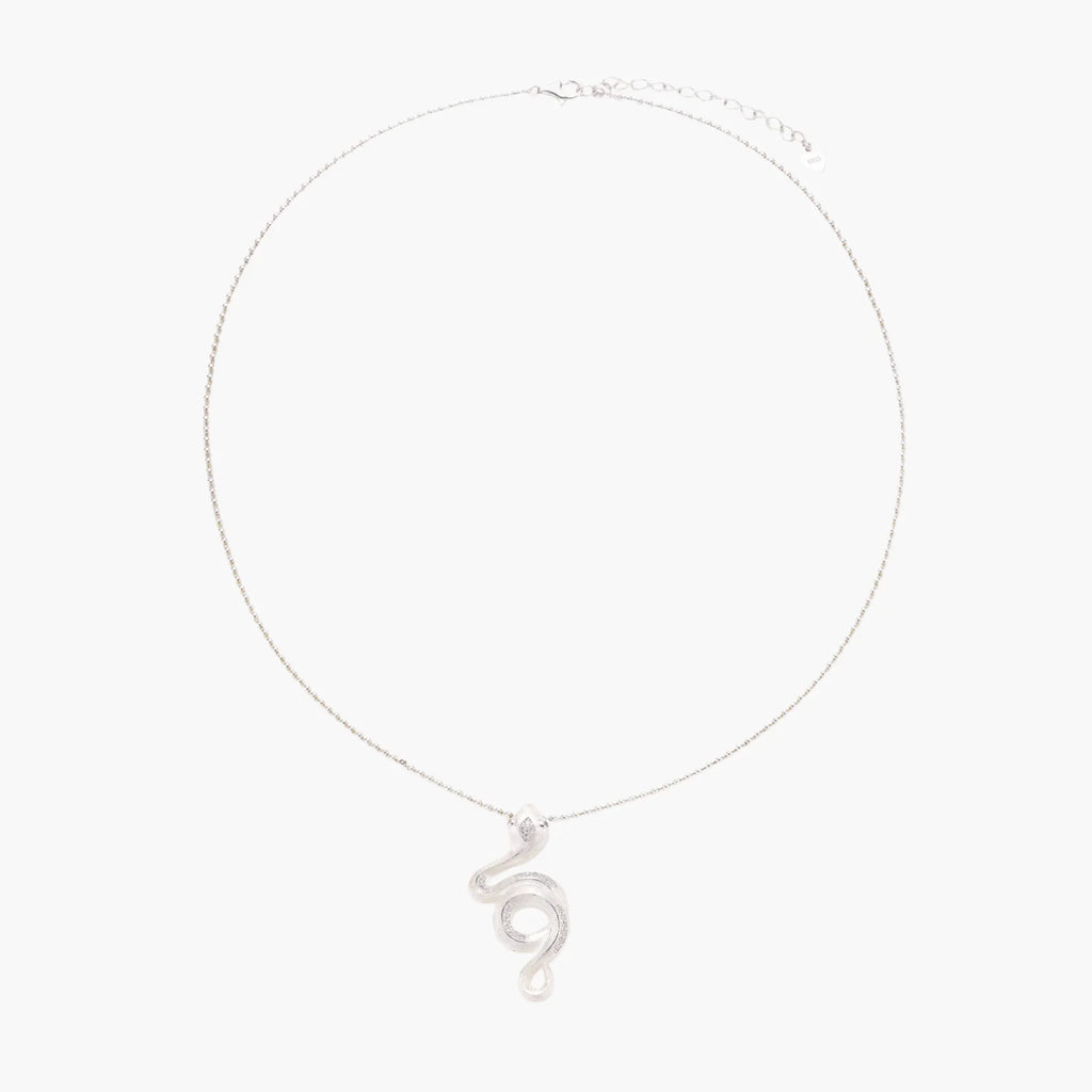 Abstract S-curve sterling silver pendant with zirconia accents on delicate chain against white background