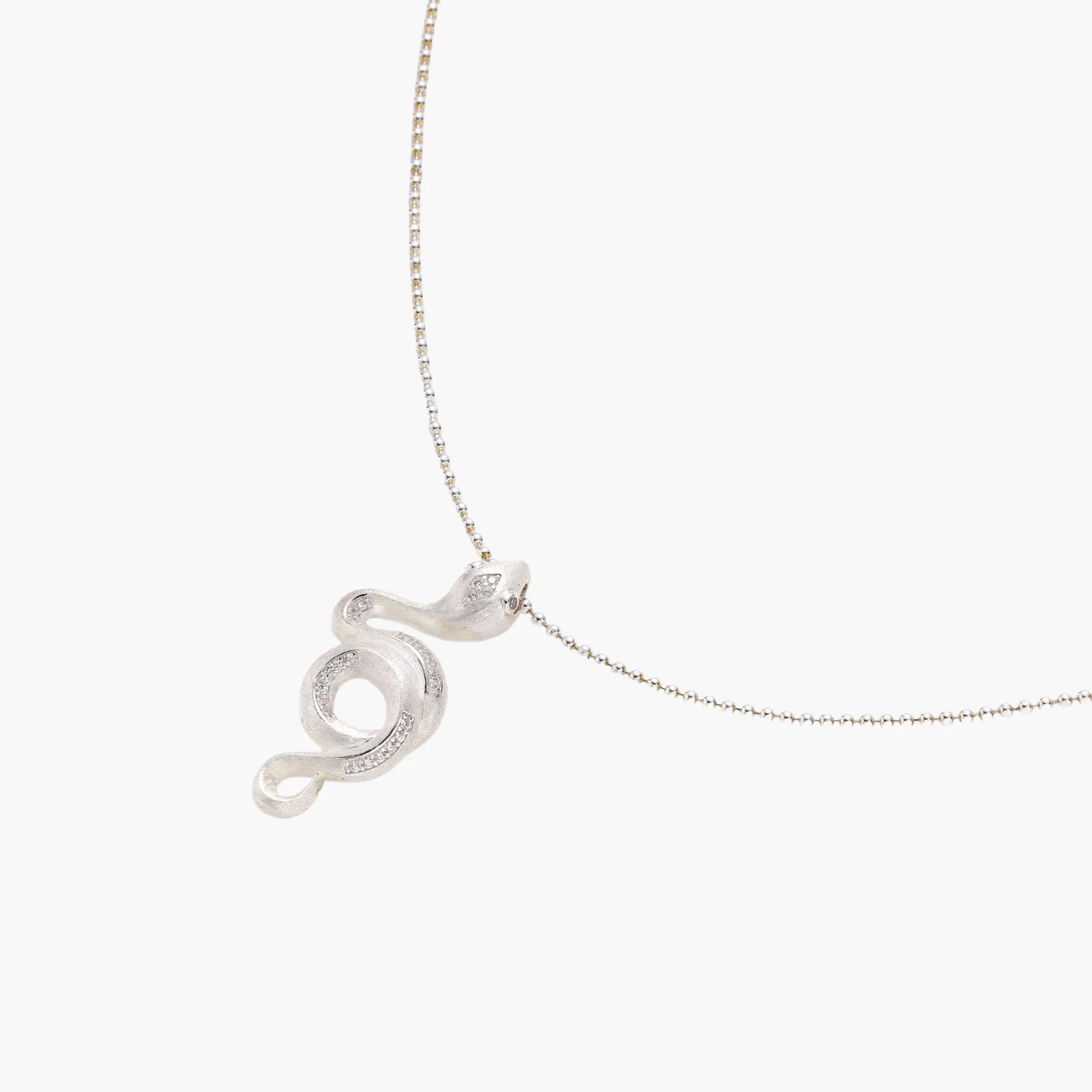 Abstract S-curve sterling silver pendant with zirconia accents on delicate chain against white background