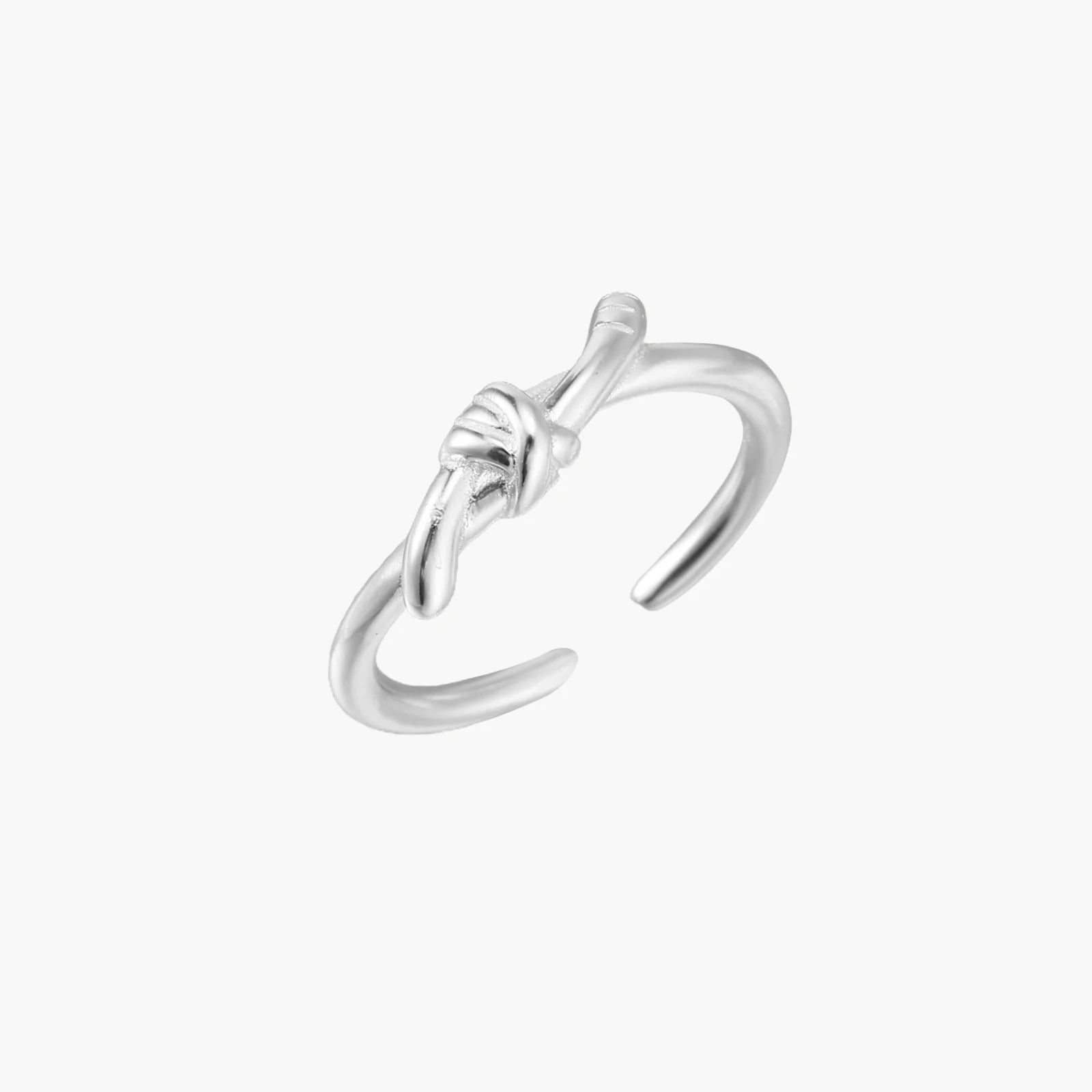 Delicate rhodium-plated silver ring with elegant knot design on cream background, adjustable band style