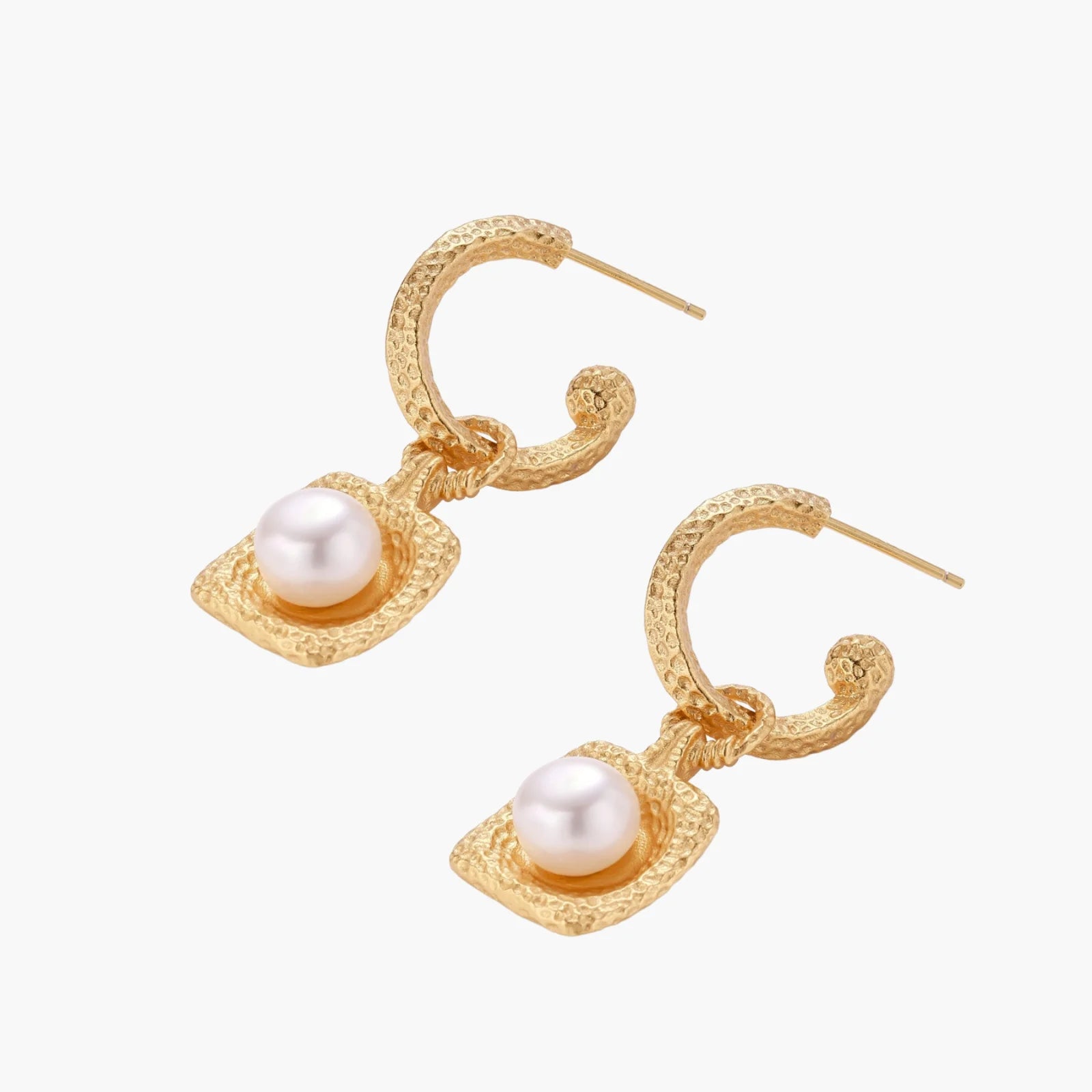 Pair of gold vermeil hoop earrings with textured square frames holding freshwater pearls on cream background