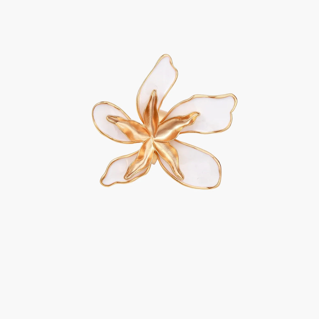 Gold-plated sculptural ring featuring white enamel petals forming an oversized lily bloom on adjustable band