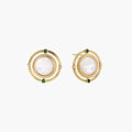 Circular gold stud earrings with iridescent mother-of-pearl center and green zirconia accents on cream background.