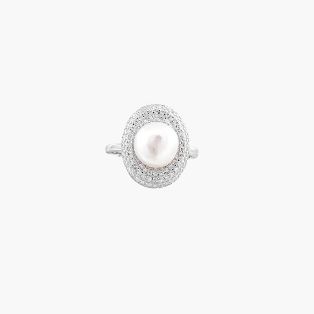 Silver ring with lustrous white pearl center surrounded by sparkling crystal halo on light background.