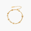 Three-strand gold-plated bracelet with clustered ball beads and adjustable clasp on cream background