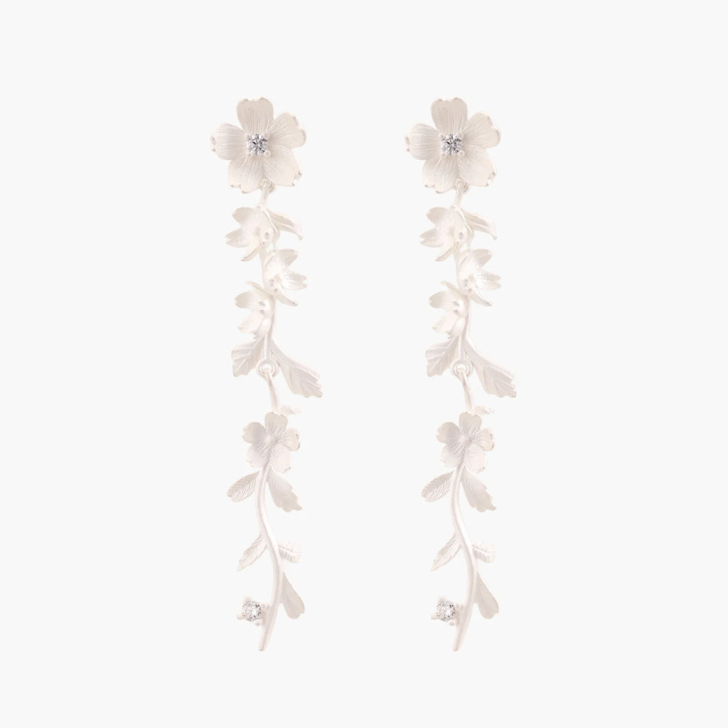 Long sterling silver drop earrings with delicate floral vine design and crystal accents on white background