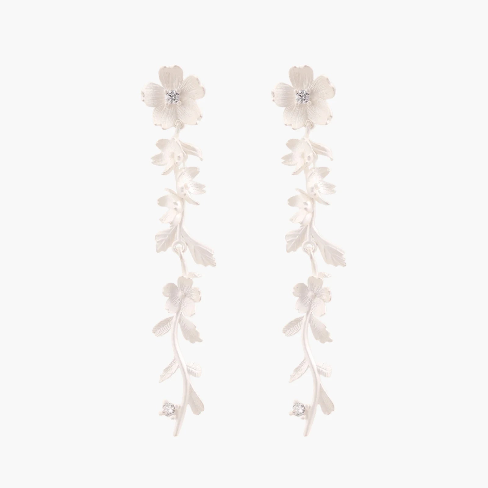 Long sterling silver drop earrings with delicate floral vine design and crystal accents on white background