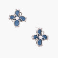 Blue denim fabric flower studs with white gold plated petals, pearl center, and zirconia accents on white background
