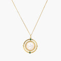 Gold pendant necklace with circular orbital design, iridescent mother-of-pearl center, and green zirconia accents