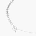 Long sterling silver beaded necklace with graduated sphere design, toggle clasp, and delicate chain extension on white background