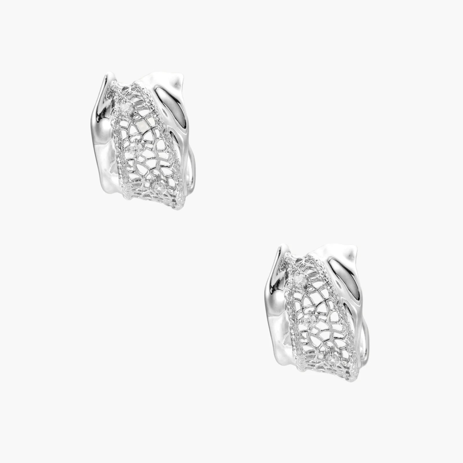 Close-up of sculptural hoop earrings with lattice center band and smooth twisted edges in white gold-plated brass with zirconia