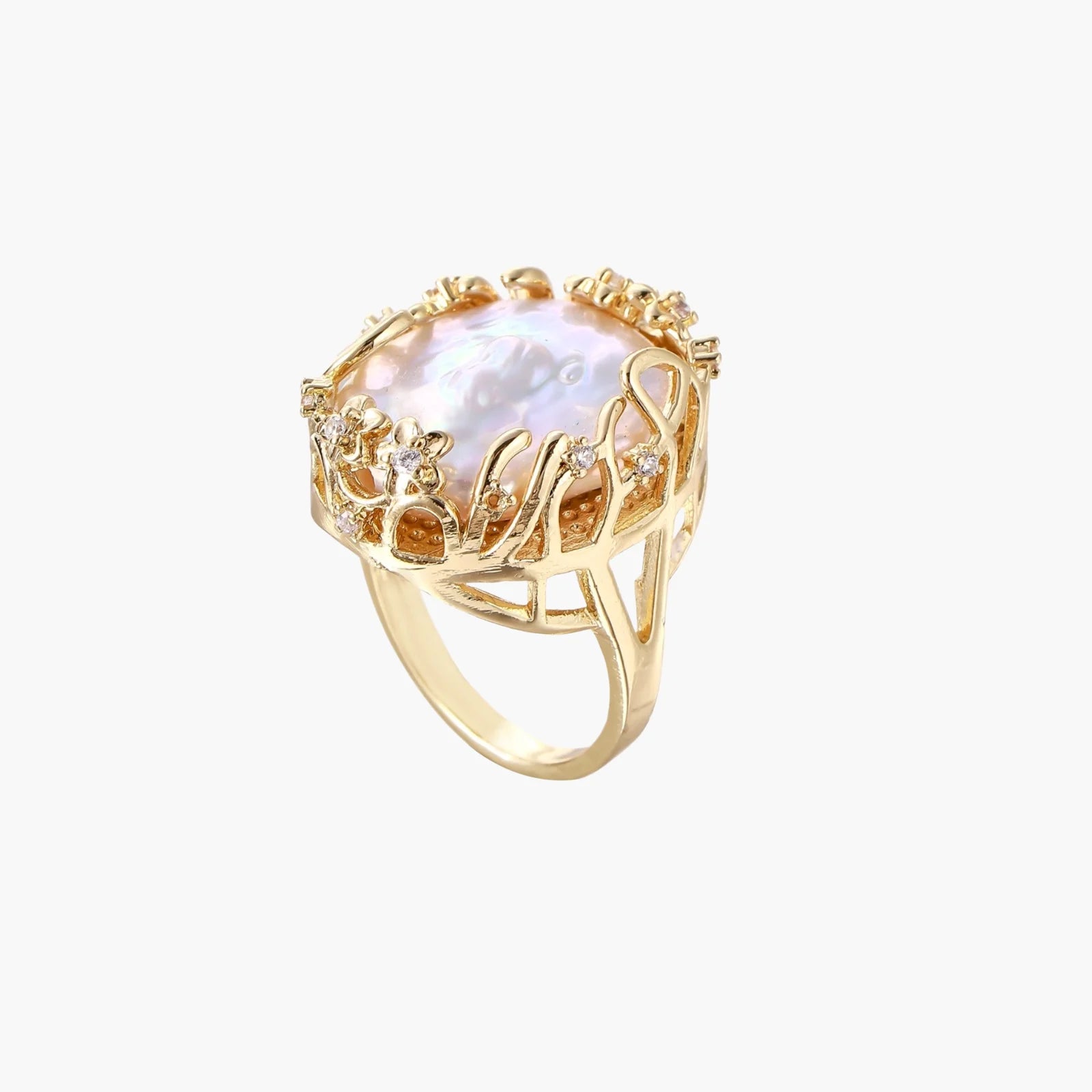 Gold filigree crown ring cradling an iridescent baroque freshwater pearl with crystal accents on white background