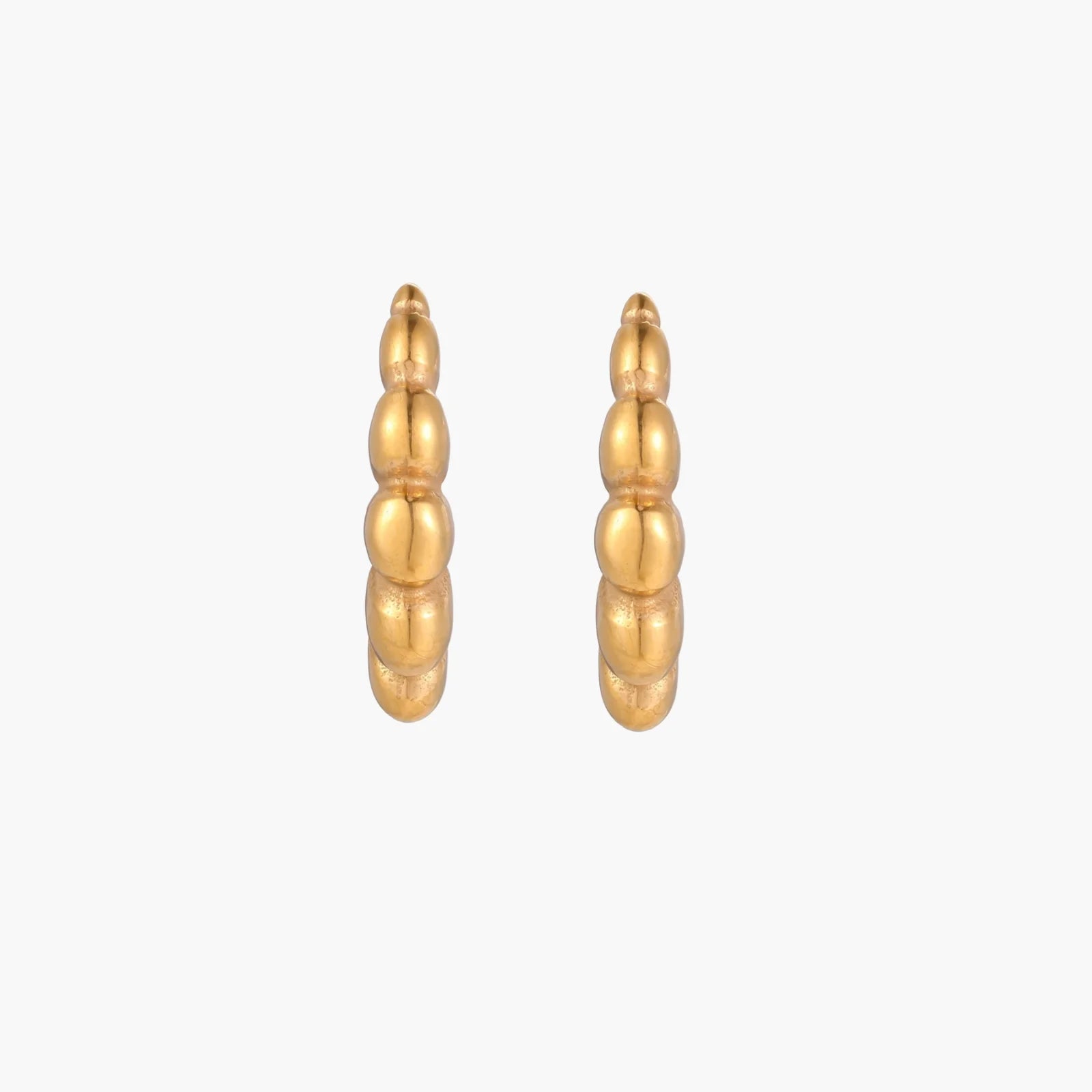 Gold-plated sculptural hoop earrings with chunky segmented design on cream background
