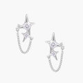 Silver star studs with crescent moon cutouts and zirconia stones connected by delicate chains on white background
