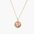 Gold pendant with pink enamel backdrop, white freshwater pearls as tulip blooms, and green leaf accents on rope chain.
