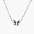 White gold plated tennis necklace with blue denim butterfly pendant and clear zirconia stones on cream background