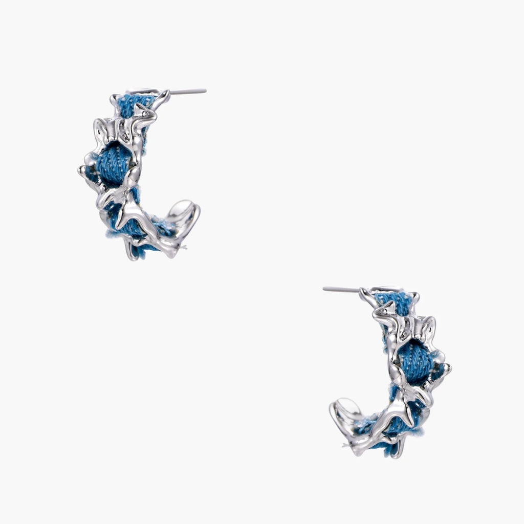 White gold plated hoop earrings with woven blue denim fabric through organic branch-like metal framework